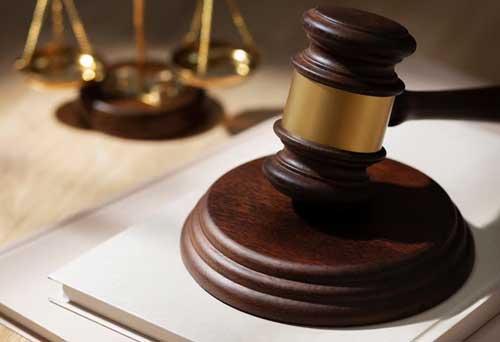 A court gavel, with a scales of justice in the background to depict Legal Risks of Not Disclosing Mold