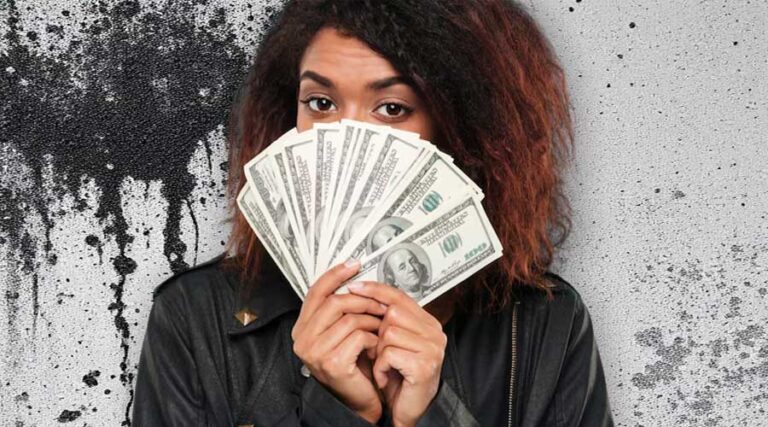 Black Mold Removal Cost image of woman holding dollars in front of a wall with black mold